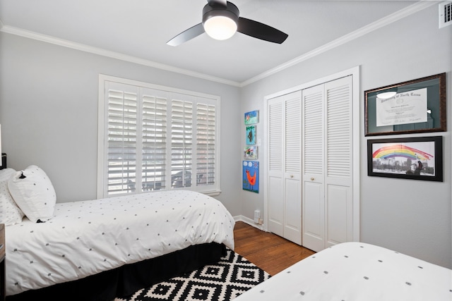 bedroom featuring a closet, visible vents, ornamental molding, a ceiling fan, and wood finished floors