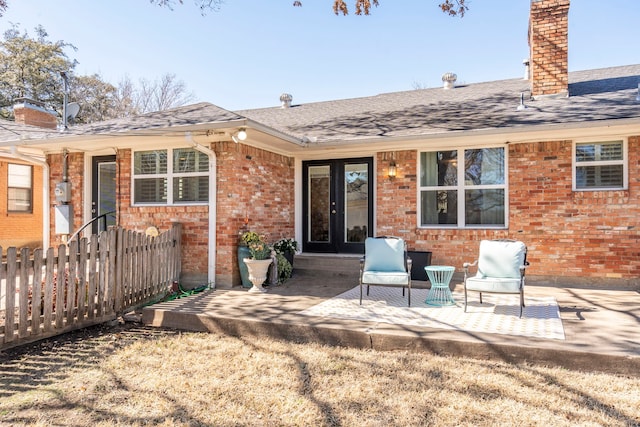 rear view of house featuring a chimney, a patio, and brick siding