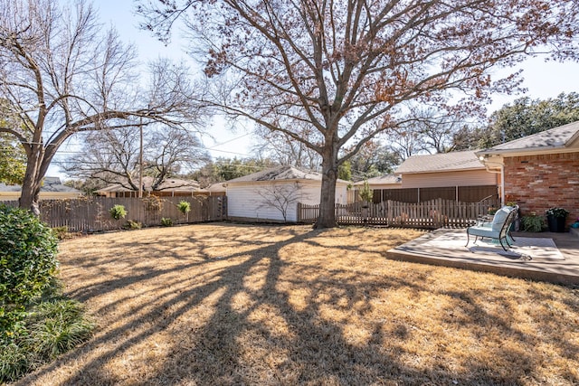 view of yard with a patio area, a fenced backyard, and an outdoor structure