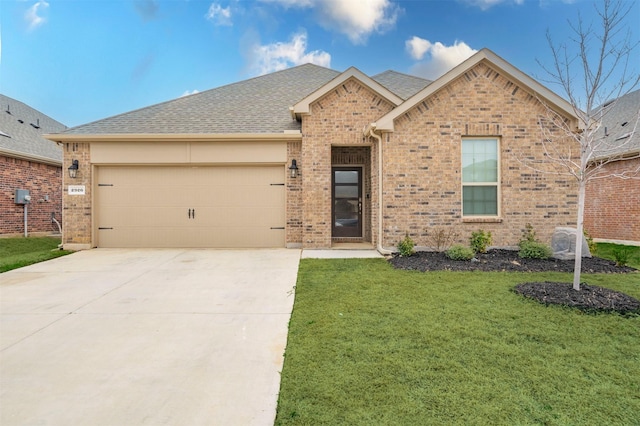 view of front facade with a front lawn, brick siding, driveway, and an attached garage