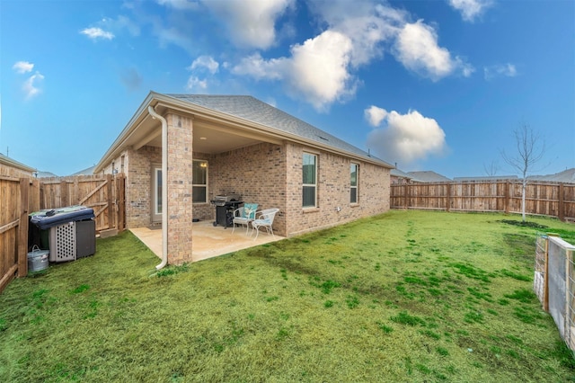 rear view of property featuring a patio, brick siding, and a fenced backyard