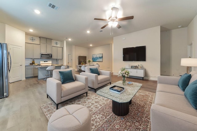 living area with recessed lighting, visible vents, ceiling fan, and light wood finished floors