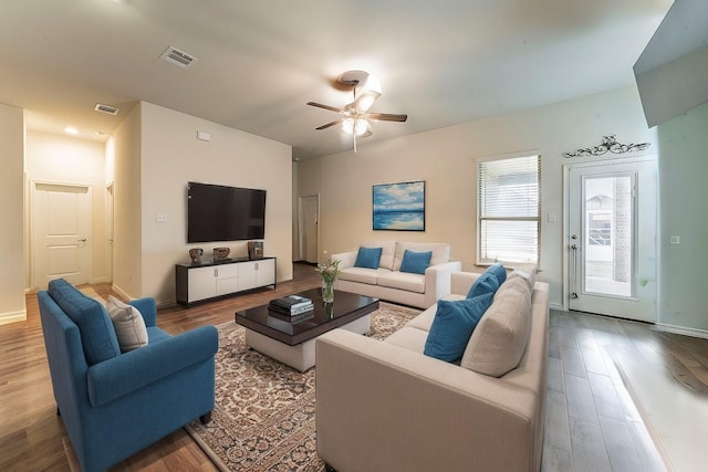 living area featuring a ceiling fan, visible vents, and wood finished floors