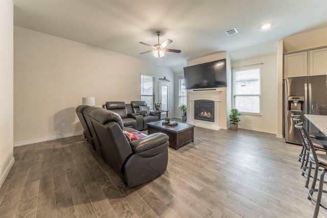 living area featuring a healthy amount of sunlight, visible vents, and wood finished floors