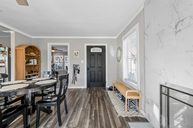 interior space featuring baseboards, ceiling fan, ornamental molding, and dark wood-style flooring