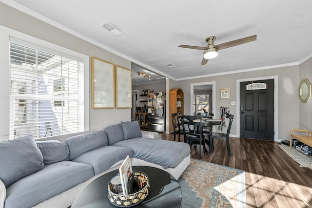 living room with visible vents, arched walkways, ceiling fan, wood finished floors, and crown molding