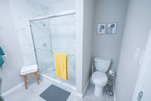 bathroom featuring tile patterned flooring, a marble finish shower, baseboards, and toilet