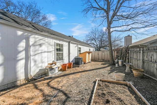 view of yard featuring ac unit, a fenced backyard, and a vegetable garden