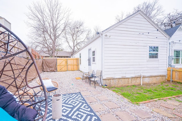 back of property featuring a patio area, a fenced backyard, and a gate