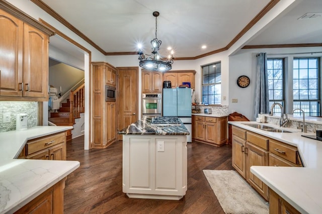 kitchen featuring visible vents, backsplash, a kitchen island, appliances with stainless steel finishes, and a sink