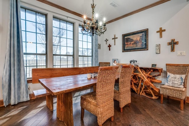 dining area with wood finished floors, visible vents, a chandelier, and ornamental molding