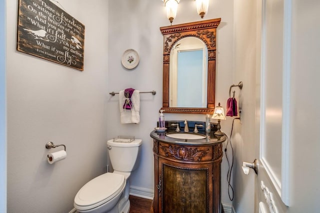 bathroom featuring baseboards, toilet, and vanity