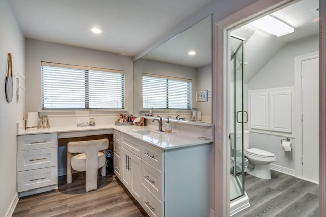 full bathroom featuring baseboards, toilet, a stall shower, wood finished floors, and vanity