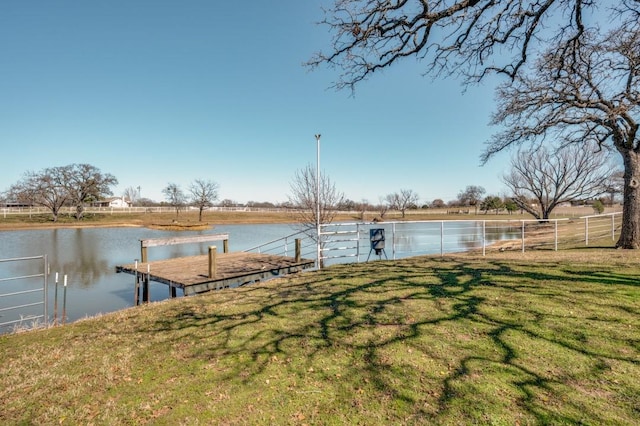 view of dock featuring a yard, fence, and a water view