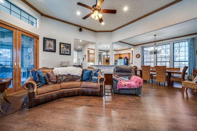 living area with dark wood finished floors, crown molding, ceiling fan with notable chandelier, and french doors