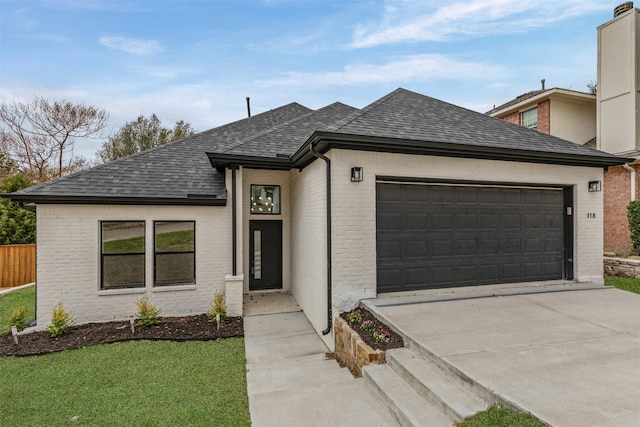 view of front of home with driveway, a shingled roof, an attached garage, and brick siding