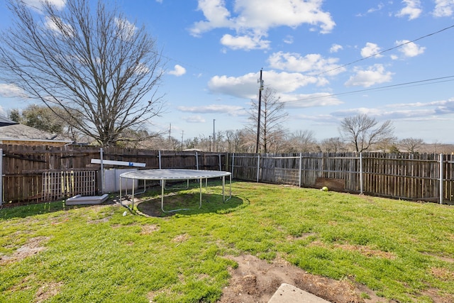 view of yard with a trampoline and a fenced backyard