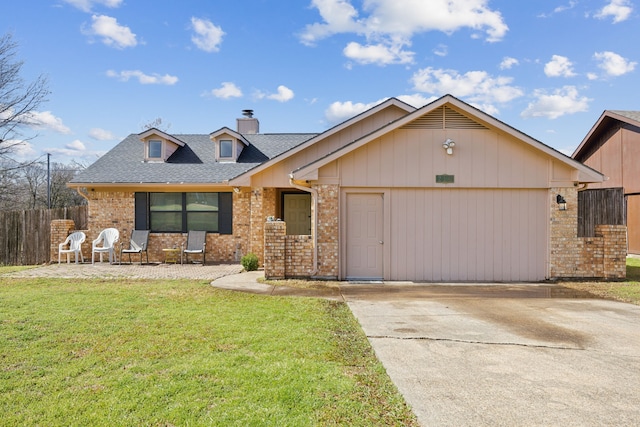 view of front facade with fence, a front lawn, concrete driveway, and brick siding