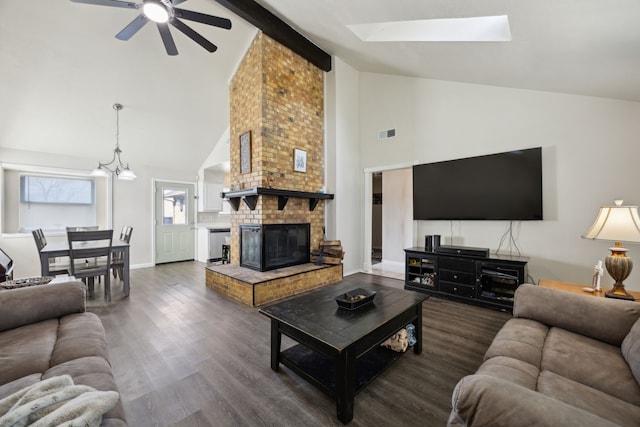 living room featuring a skylight, a fireplace, dark wood finished floors, visible vents, and baseboards