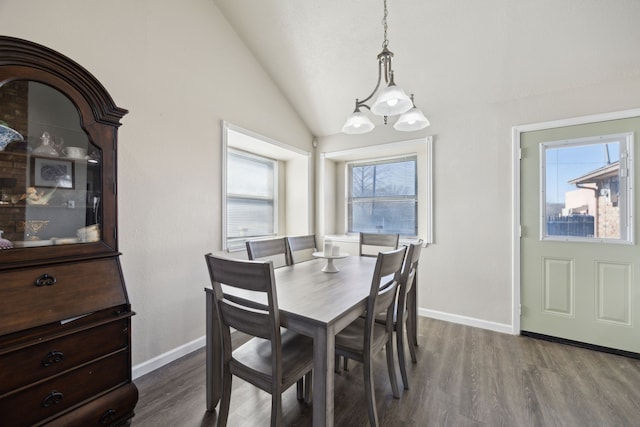 dining space with vaulted ceiling, wood finished floors, and baseboards