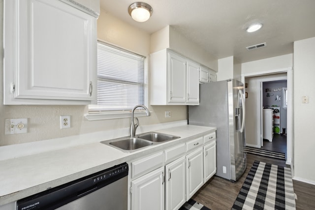 kitchen with a sink, visible vents, white cabinets, light countertops, and appliances with stainless steel finishes