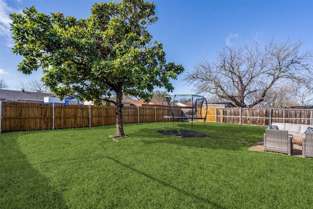 view of yard with a trampoline and a fenced backyard