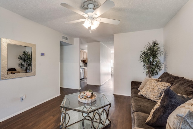 living room with visible vents, dark wood-type flooring, ceiling fan, a textured ceiling, and baseboards