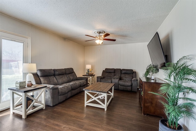 living area featuring a textured ceiling, a ceiling fan, and wood finished floors