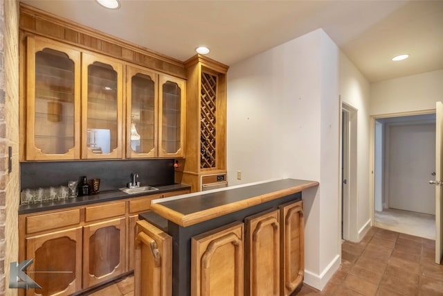 bar with light tile patterned flooring, recessed lighting, a sink, baseboards, and decorative backsplash