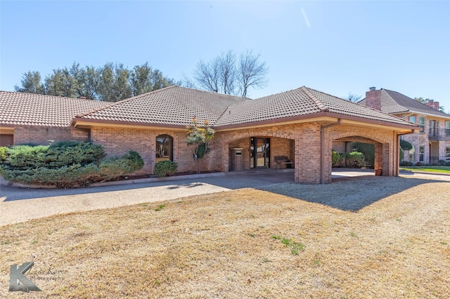 view of front of home featuring brick siding and a tiled roof