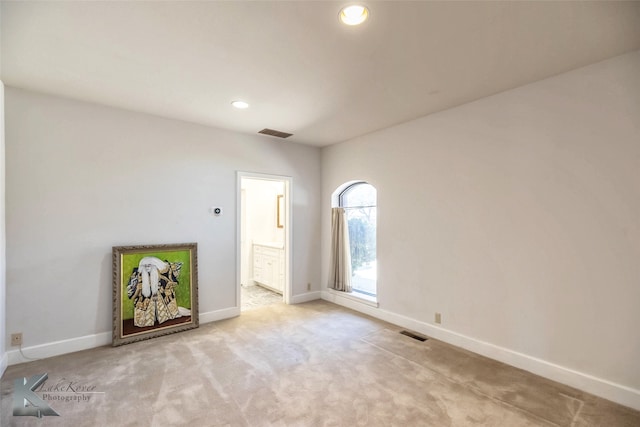 spare room with light carpet, recessed lighting, visible vents, and baseboards