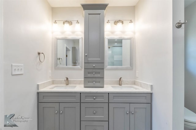 full bathroom with a shower, a sink, toilet, and double vanity