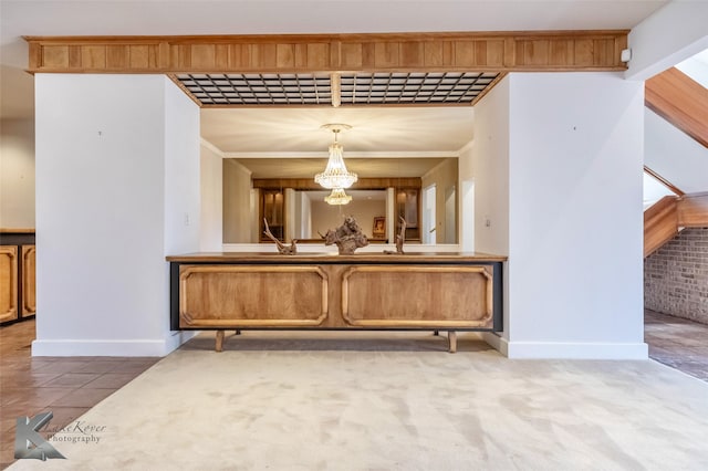 bar featuring a chandelier, tile patterned flooring, stairway, and baseboards