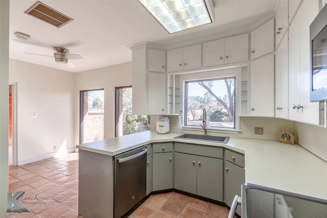 kitchen with light countertops, visible vents, a sink, dishwasher, and a peninsula