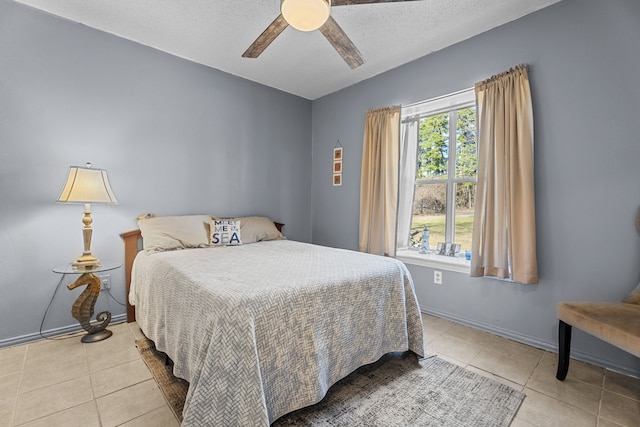 bedroom with ceiling fan, baseboards, a textured ceiling, and tile patterned floors