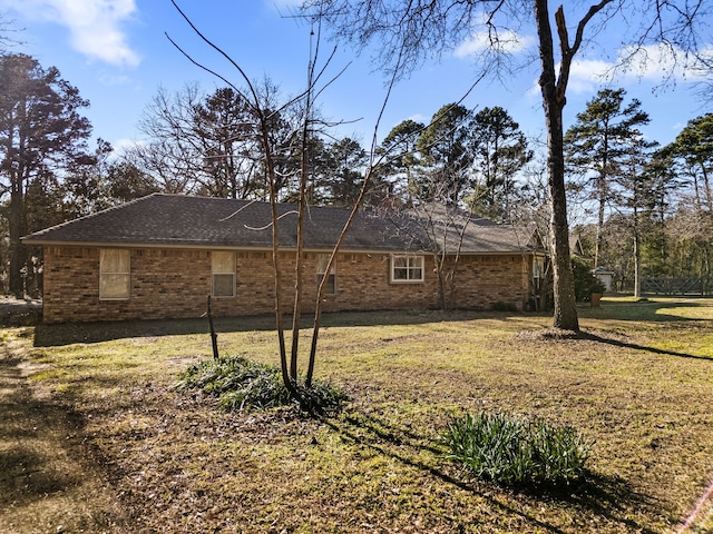 view of side of home featuring a yard and brick siding