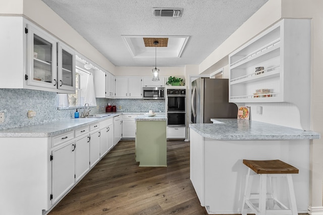 kitchen with visible vents, white cabinets, dark wood finished floors, appliances with stainless steel finishes, and a sink