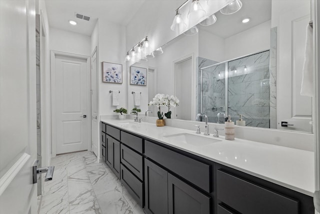 full bath featuring marble finish floor, a marble finish shower, double vanity, visible vents, and a sink