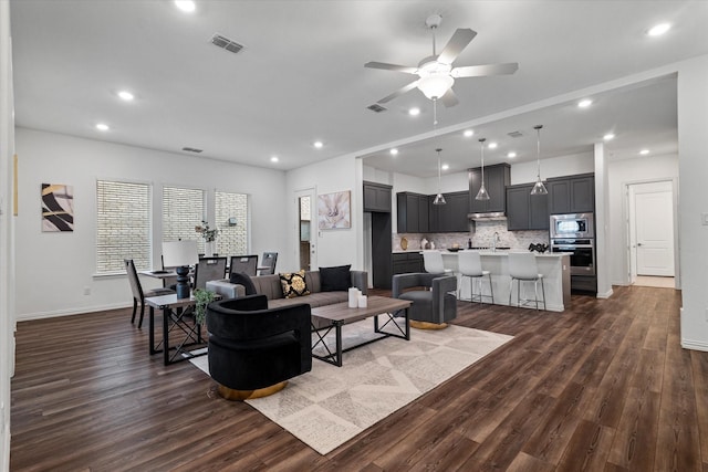 living room featuring visible vents, dark wood-type flooring, and recessed lighting