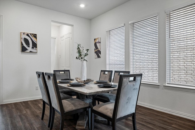 dining space featuring dark wood finished floors and baseboards