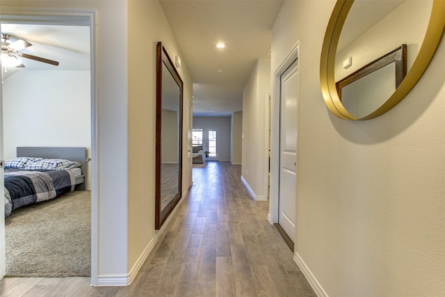 hallway with wood finished floors and baseboards