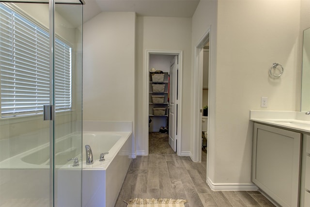 full bath featuring a bath, baseboards, wood finished floors, and vanity