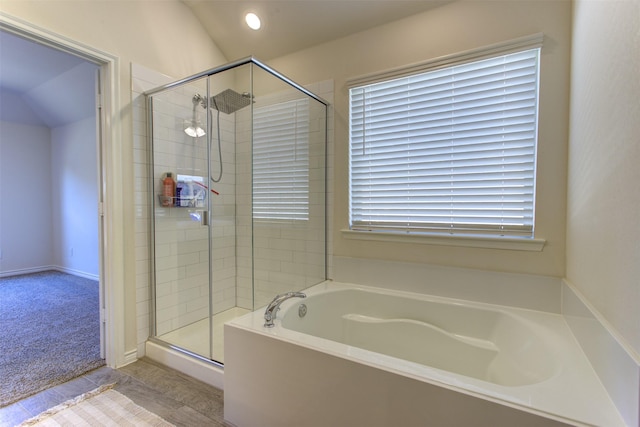 bathroom with vaulted ceiling, a stall shower, and a garden tub