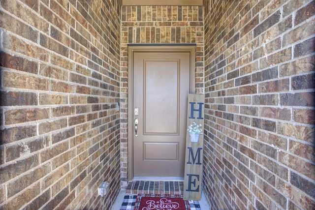 property entrance featuring brick siding