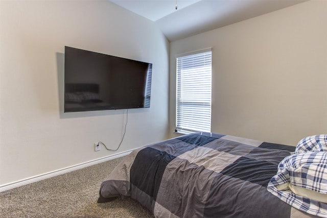 carpeted bedroom with vaulted ceiling and baseboards