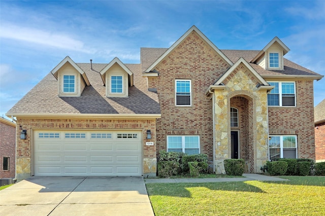 traditional home with driveway, brick siding, a front yard, and roof with shingles