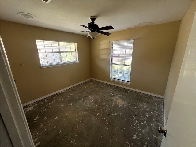 spare room featuring a ceiling fan and baseboards