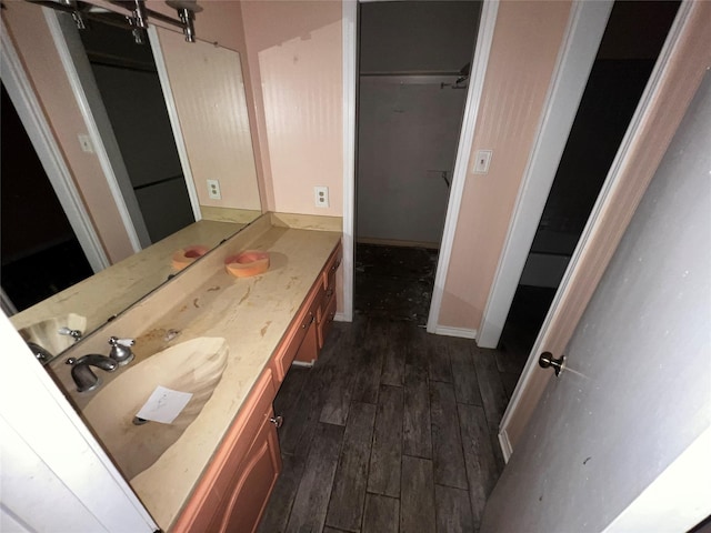 bathroom featuring vanity, wood finished floors, and baseboards