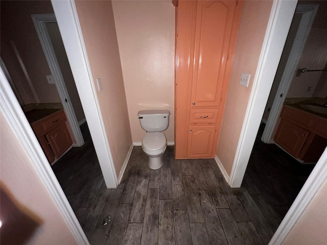 bathroom featuring toilet, baseboards, and wood finished floors