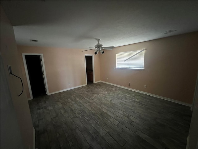 unfurnished room featuring visible vents, baseboards, a ceiling fan, and dark wood-style flooring